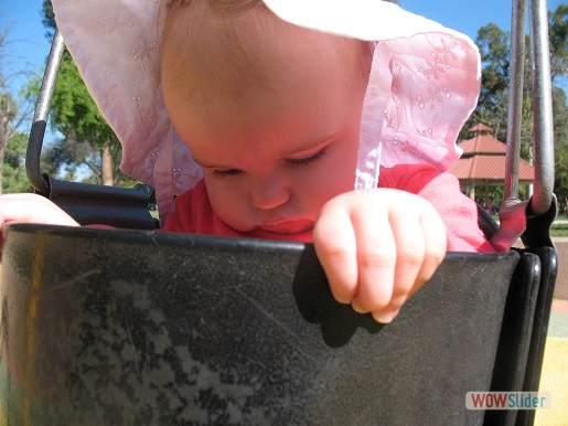 a baby is sitting in a swingset